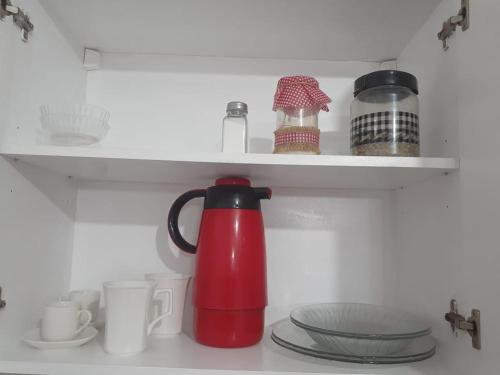 a red tea kettle is sitting in a refrigerator at Monoambiente céntrico in Paraná