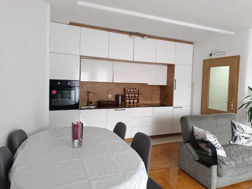 a living room with a table and a kitchen at Redon Apartment in Pristina