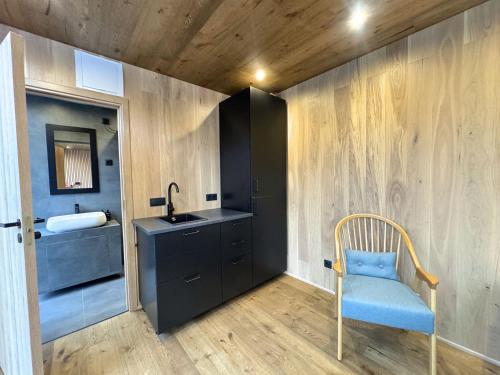 a bathroom with a sink and a blue chair at Brygga på Dønna in Berfjorden