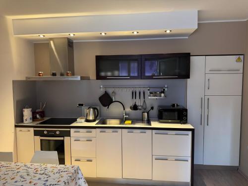 a kitchen with white cabinets and a counter top at Daisy in Lokev