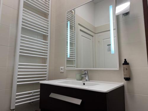 a bathroom with a sink and a mirror at Hotel des Pins in Soulac-sur-Mer