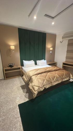 a bedroom with a large bed with a green wall at Hotel MEDINA in Oran