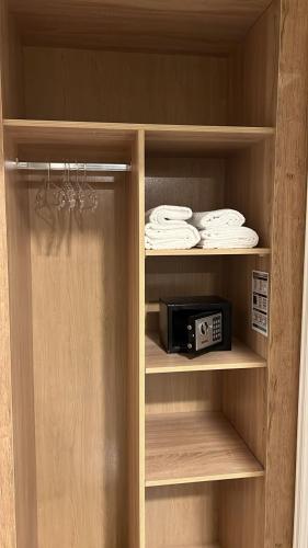 a cupboard with a microwave and some towels at Hotel MEDINA in Oran