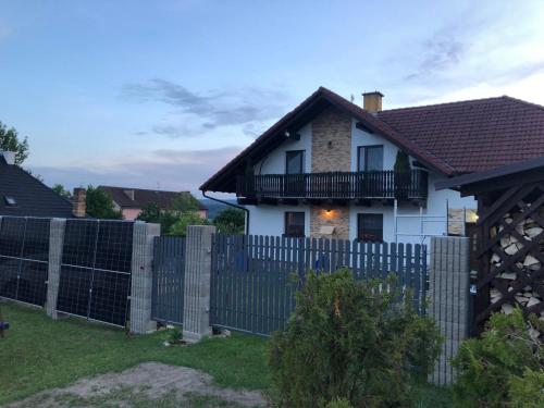 a fence in front of a white house at Květinové apartmány Horní Planá in Horní Planá