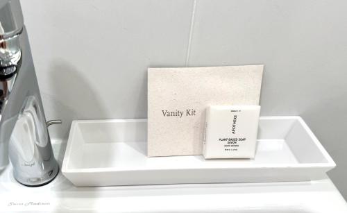 a white tray with a candle and a box on it at Wainscott Woods Retreat in Wainscott