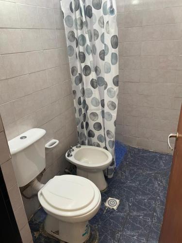 Un baño con inodoro y cortina de ducha. en Casa de Gregorio, en Córdoba
