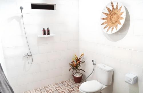 a white bathroom with a toilet and a shower at Villa Mimoza Umalas Bali in Kerobokan