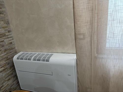 a white refrigerator sitting next to a window at Ohana Dream House in Alghero