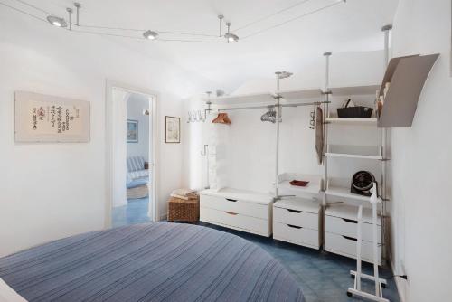 a white room with white cabinets and a ladder at Casa Il Geco Praiano in Praiano