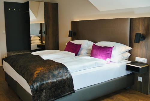 a bedroom with a large white bed with purple pillows at Residence Black Eagle Lubmin Strand in Lubmin