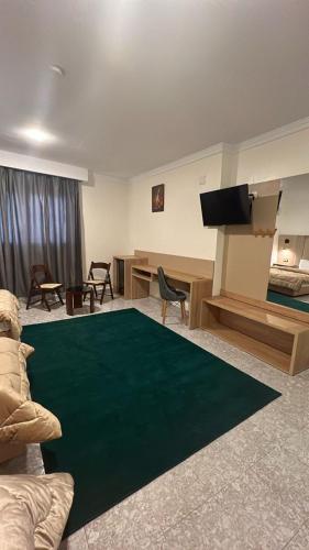 a living room with a green rug on the floor at Hotel MEDINA in Oran
