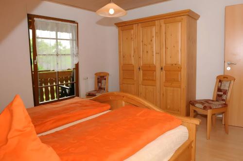 a bedroom with a bed and a window and a chair at Suschethof in Oppenau