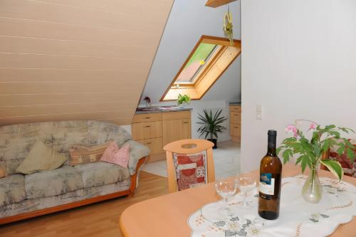 a living room with a couch and a table with a bottle of wine at Suschethof in Oppenau