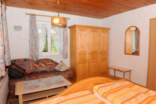 a bedroom with a bed and a couch and a table at Suschethof in Oppenau