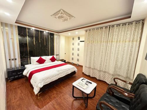 a bedroom with a bed and a table and a couch at Decent Luxury Hotel Hunza in Alīābād