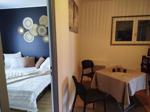 a room with a table and a bed and a table and chairs at Parenthèse Aiyanna in Moux-en-Morvan