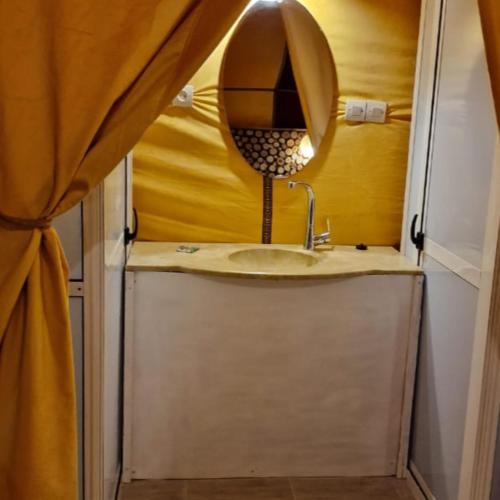 a bathroom with a sink and a mirror at Luxury camps merzouga in Merzouga