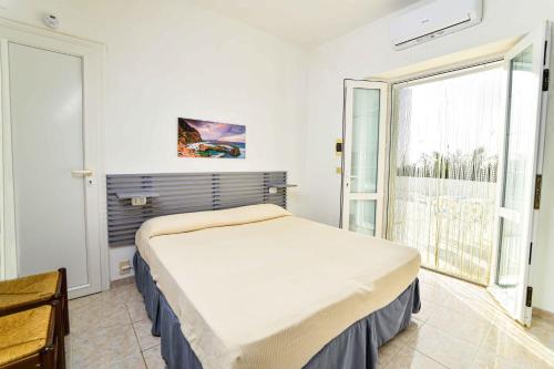 a bedroom with a bed and a large window at SoleMarePonza Casa Maria in Ponza