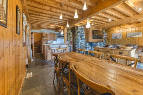 une salle à manger avec une grande table et des chaises en bois dans l'établissement Gabbro-Chalet Moderne Tout Confort, à Villard-Reculas