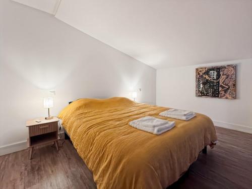 Un dormitorio con una cama grande con dos toallas encima. en L'art de vivre en Baie, bel apt avec parking, en Saint-Valery-sur-Somme