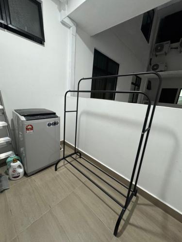 a metal bed in a room with a trash can at Qila Homestay at DESARU UTAMA in Bandar Penawar