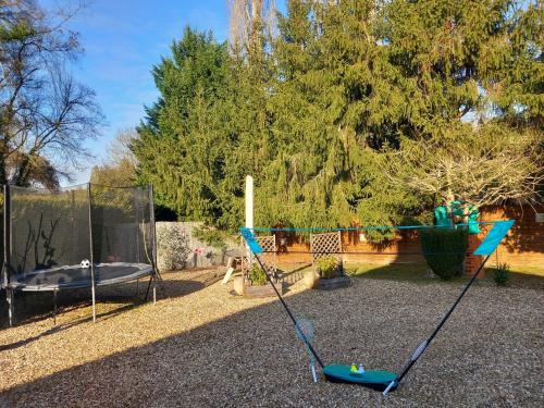 une aire de jeux avec balançoire et trampoline dans l'établissement Le Cottage de Maé, à Seigy