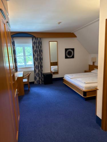 a hotel room with a bed and a desk at Gasthof-Hotel Goldenes Schiff in Engelhartszell