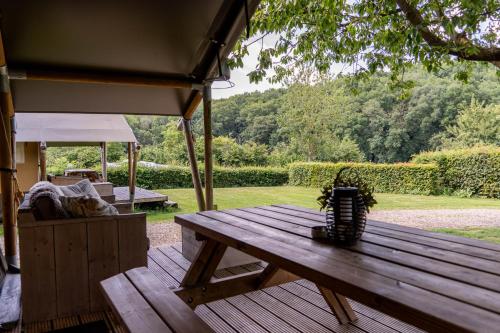 a wooden picnic table sitting on a deck in a yard at Camping De Bosrand in Sint Geertruid