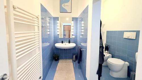 a blue bathroom with a sink and a toilet at J03 - Jesi, elegante trilocale vicino al centro in Iesi