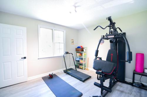 a room with a gym with a treadmill at Private 1 Acre Retreat, Spa, Firepit, Gym, Chickens, King Suite, Pets in Wake Forest