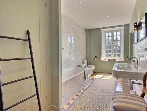 une salle de bain avec une baignoire, des toilettes et un lavabo dans l'établissement Château de Cadouzan, à Saint-Dolay