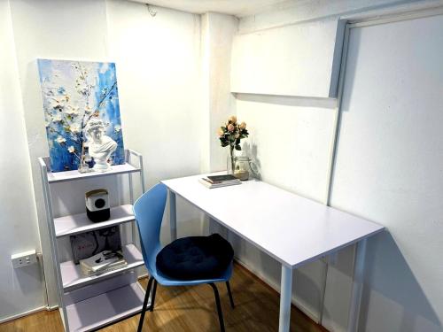 a white desk with a blue chair in a room at Heart of Hoan Kiem-RARE 5BR Private house unique design travel hub 13pax in Hanoi