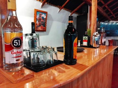 two bottles of alcohol sitting on top of a bar at Andenes del Inca Hotel in Ollantaytambo