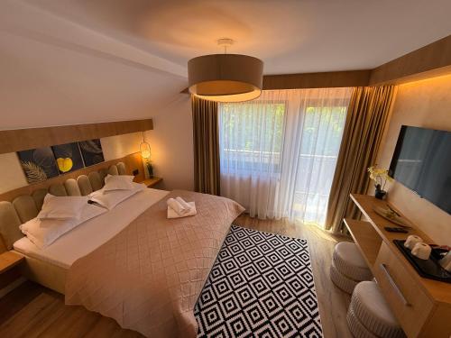 a bedroom with a bed and a flat screen tv at Alpin Vista in Buşteni