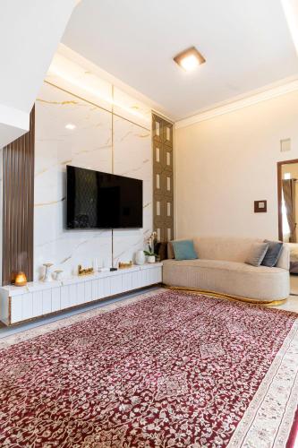 Una sala de estar con un sofá y un televisor de pantalla plana. en Griya Genitri, en Malang
