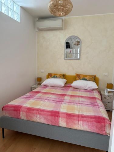 a bedroom with a large bed with a colorful blanket at Residence Mona Lisa bord de mer Menton in Menton