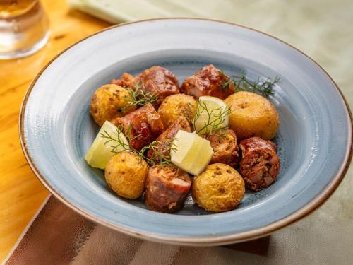 a blue bowl of food with potatoes and cheese at Hotel Alma in Villa de Leyva