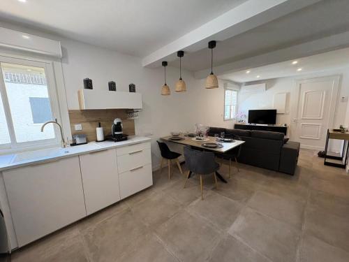 a kitchen and living room with a table and a couch at Chez Isa, Les pieds dans l'eau in Valras-Plage