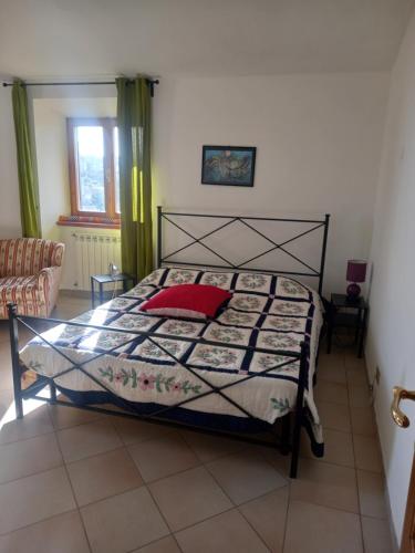a bedroom with a bed with a red pillow at Autenticum Agriturismo Tolfa in Tolfa