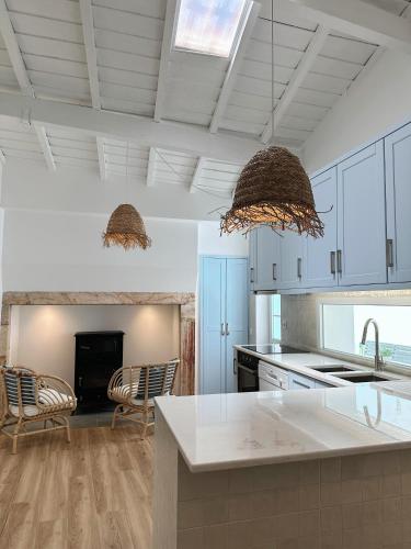 a kitchen with white cabinets and a kitchen island at Casas do Largo- Primavera in Estremoz