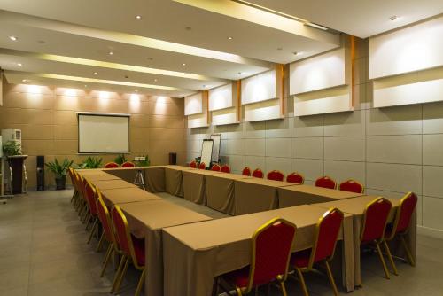 a conference room with tables and chairs and a screen at Jinjiang Inn Baoding Railway Station in Baoding