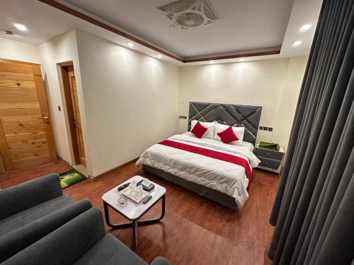 a hotel room with a bed and a couch at Decent Luxury Hotel Hunza in Alīābād