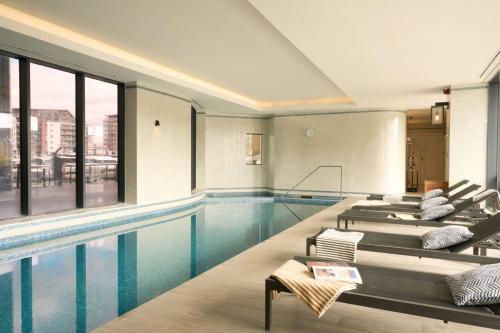 a swimming pool with several lounge chairs next to it at Harbour Hotel & Spa Southampton in Southampton