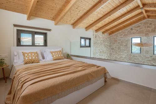 a bedroom with a large bed and a stone wall at Petra Natura Villa in Zakynthos Town