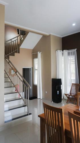 a living room with a staircase and a table and chairs at Villa Cijeruk i1 - View Gunung Salak in Cihideung