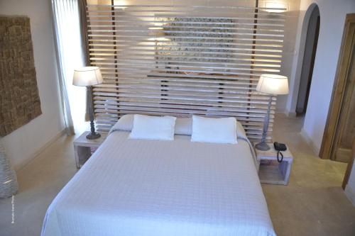 a bedroom with a large white bed with two lamps at Le Scuderie - Castello Monaci in Salice Salentino