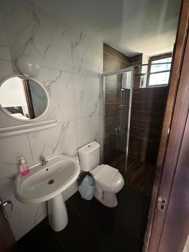 a bathroom with a sink and a toilet and a shower at Karpaz Arch House Hotel in Rizokarpaso