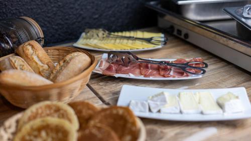 a table topped with plates of bread and cheese at Urban Style Arl HOTEL in Arles