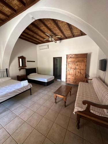 a large room with two beds and a table at Karpaz Arch House Hotel in Rizokarpaso