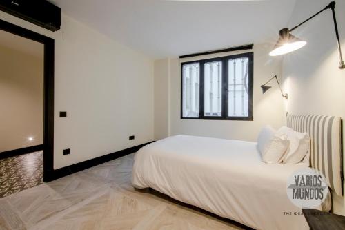 Un dormitorio blanco con una cama grande y una ventana. en Un Madrid moderno para 7, tu refugio en Abada 2 E2, en Madrid